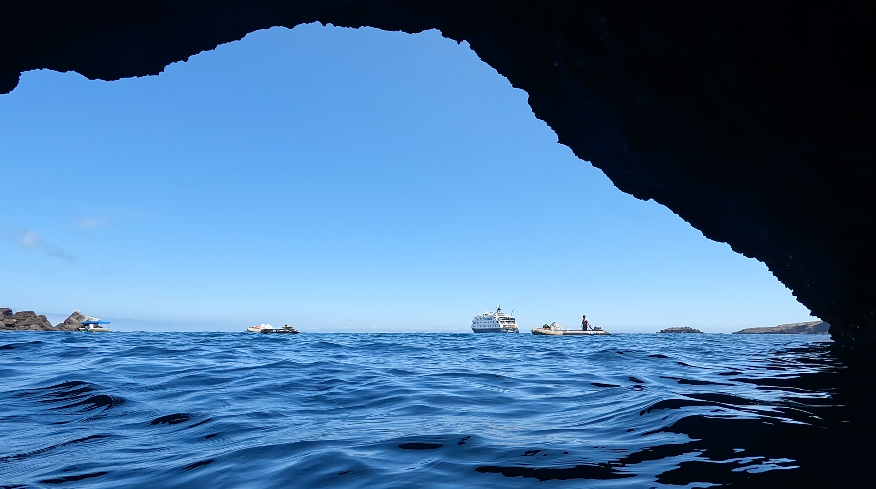 A cave entrance nicely framed up our ship, the Zodiacs, and the ship&#039;s glass bottom boat (key in identifying exactly what we&#039;re looking at when we were looking at it).